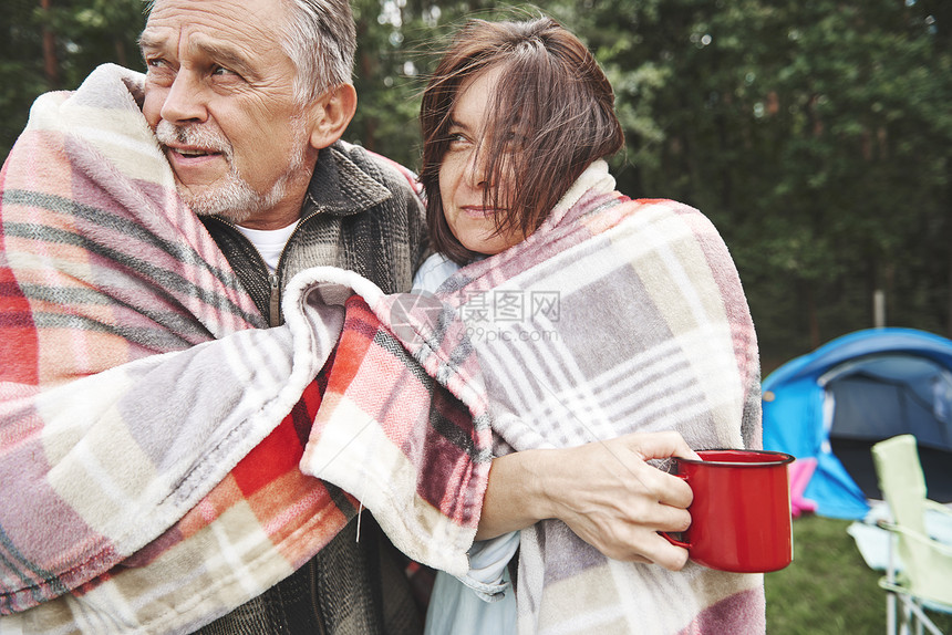 一对成熟夫妇用毛毯包着站在帐篷旁边图片