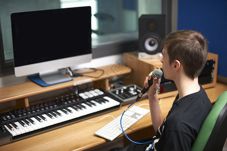 年轻男大学生在录音室用麦克风说话图片
