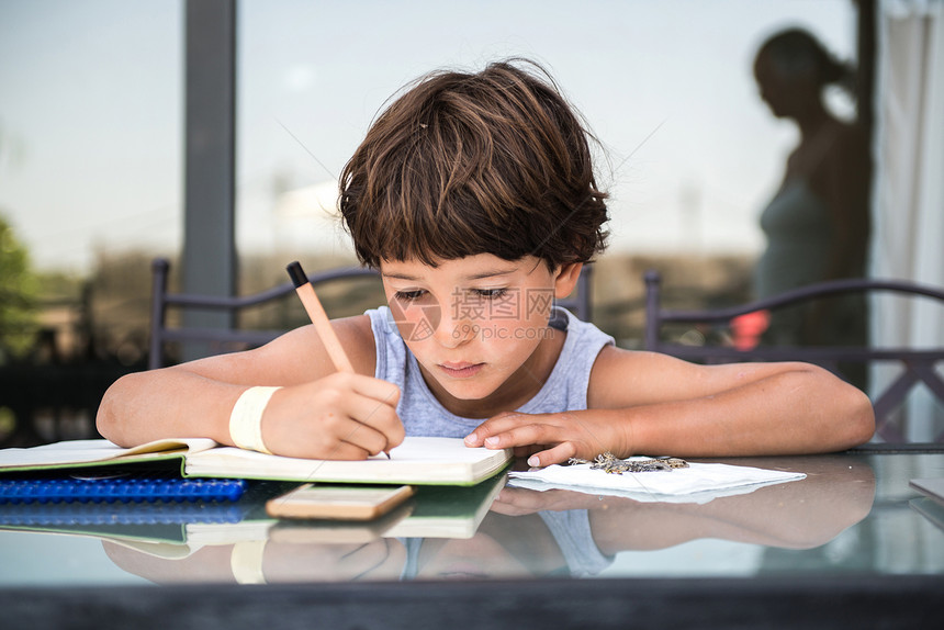 在桌子上写作业的男孩图片