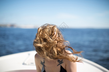 女人在船上头发吹风遮脸图片