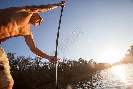 低角度水上使用桨的男青年图片