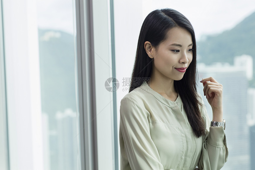 女职员微笑地看窗外图片