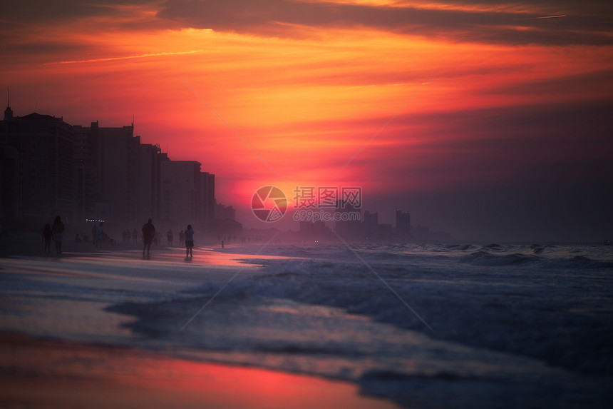日落时海滩上的人们图片