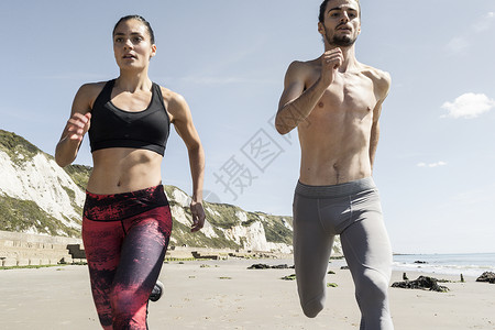 男女青年在海滩上奔跑图片