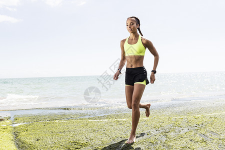 光脚在海边奔跑的年轻女子背景图片