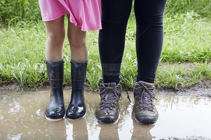 两个女孩站在泥水图片