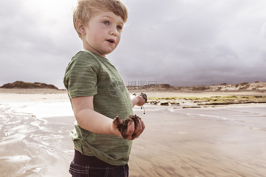 年轻男孩在海上玩泥巴图片