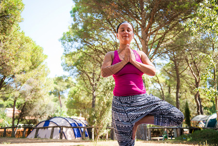 在露营现场做瑜伽姿势的女人图片
