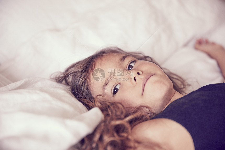 年轻女孩躺在床上沉思图片