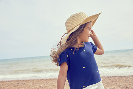 年轻女孩站在沙滩上远望图片