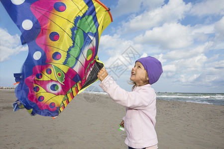 女孩在海滩上飞风筝图片