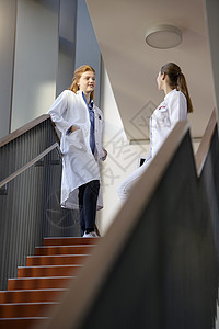两名女医生在最高阶梯上进行讨论低角度观点图片
