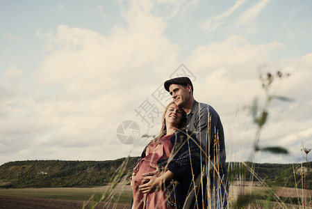 田间幸福的怀孕的夫妇肖像图片