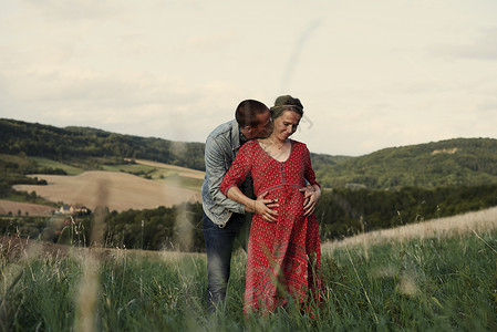 浪漫的男人拥抱着怀孕的妻子图片