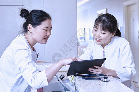 医院接待台用平板电脑的两个医生图片
