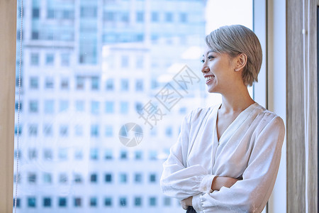 商务女性的肖像看着窗外的微笑图片