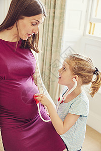 带着玩具听诊器的女孩孕妇的肚子图片