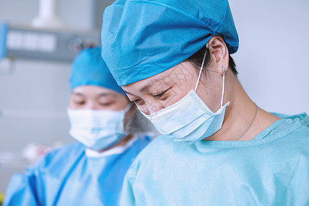在产科手术室低头看的女外科医生图片