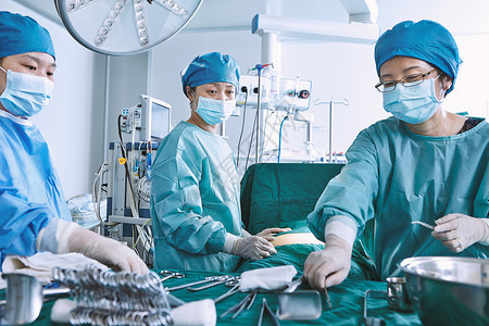 在产科手术室对的病人腹部进行手术的外科医生图片