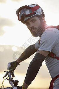 阳光下男子山上骑自行车图片