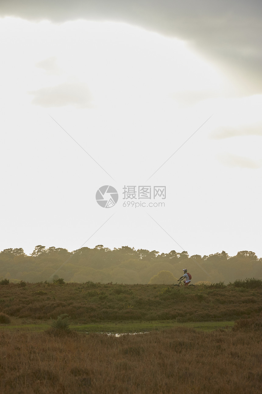 雄山骑自行车在荒地上骑自行车的远视图片