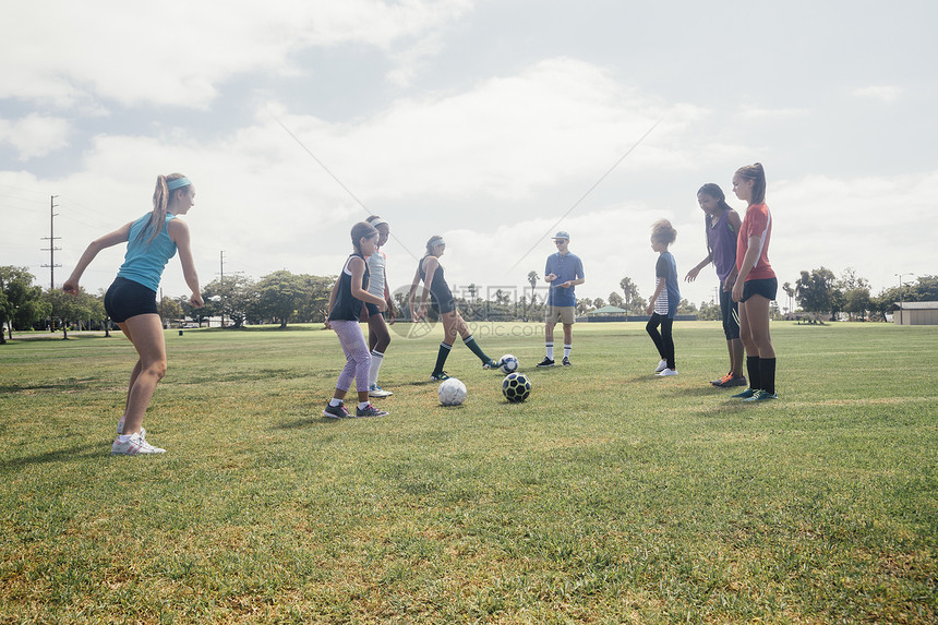 在校运动场上女学生面对面踢足球图片