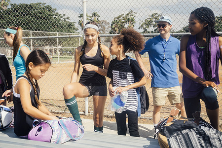 教师和女足球运动员在学校操场准备练习图片
