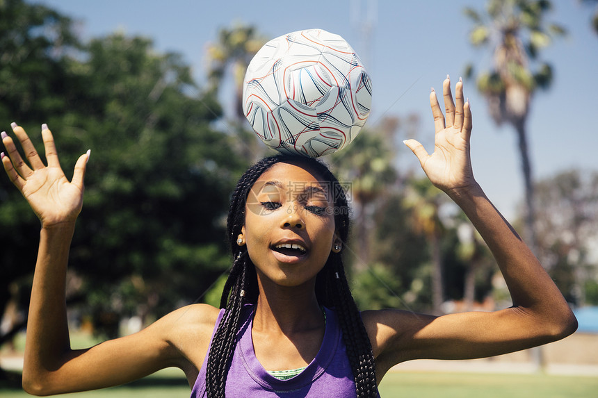 在校运动场上女足球运动员在头上顶着一个球图片