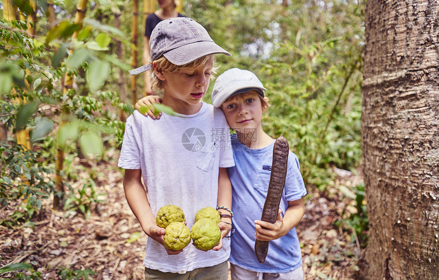 南美洲玻利维亚丘基萨卡阿古斯卡连特斯丛林中抱着椰子和种子的男孩图片