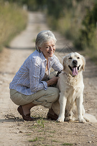 在宠物狗旁边蹲着的老女人肖像图片