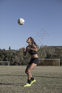 在足球场上踢足球的女人图片