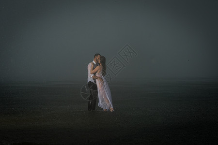潮湿夫妇在薄雾沙滩上图片