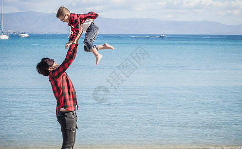 父亲和儿子在海滩上父亲空中抬起儿子图片