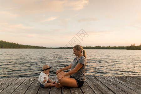 母亲与女婴面对面坐在码头上图片