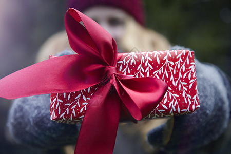 女人拿着带有红丝带的圣诞礼物图片