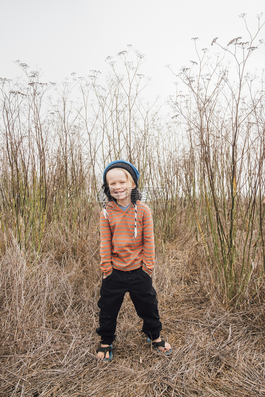 乡村环境中男孩的肖像手放在口袋里微笑图片