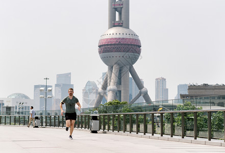 在上海金融中心跑步的年轻男人图片
