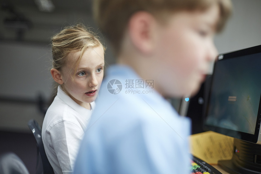 小学女生和男生在教室里使用电脑图片