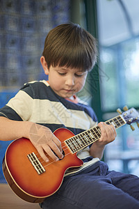 在小学课堂上玩吉他的男孩子图片
