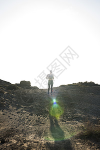 西班牙加那利群岛拉斯帕尔马斯干旱地区跑步的年轻女跑步者图片