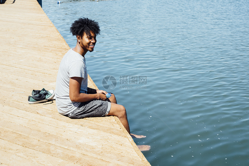 男人坐在水边图片