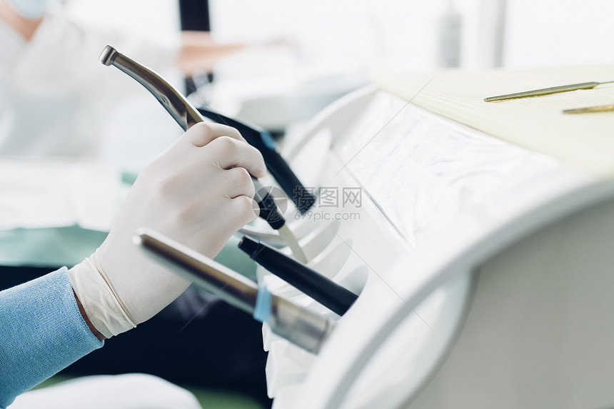 牙科护理设备台上医生拿着设备的手图片