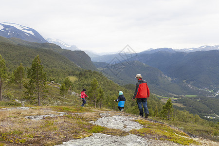 挪威奥普兰洛美佐敦海门公园带着儿子在山中徒步旅行的男人图片