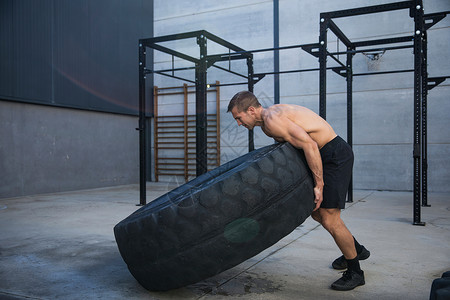 男子在健身房锻炼举重轮胎图片