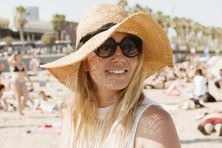 沙滩上戴着太阳帽的女性图片