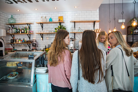 三个女人站在咖啡馆柜台前图片