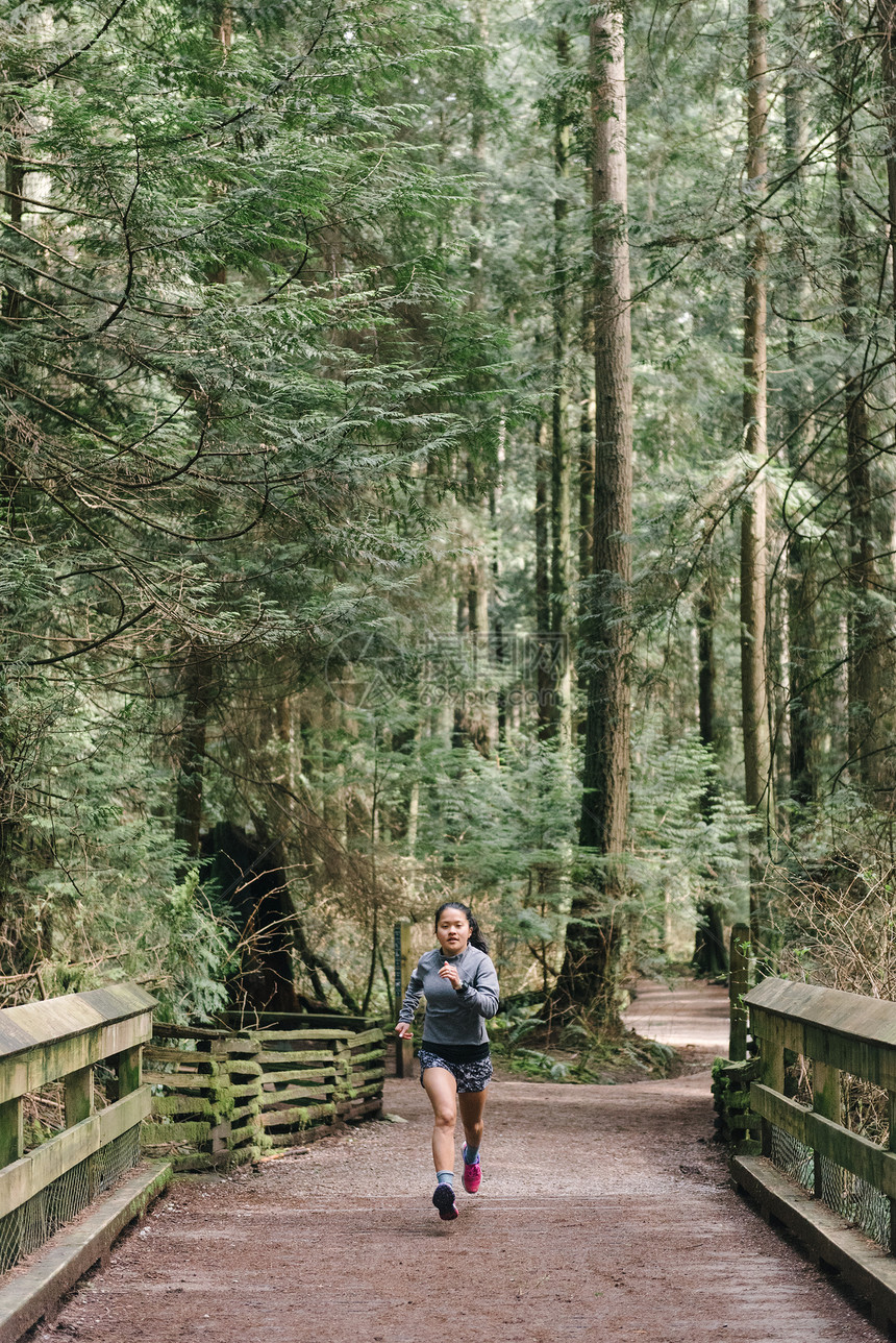 在加拿大温哥华森林中奔跑的妇女图片