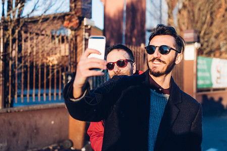 意大利米兰用手机自拍的两个朋友图片