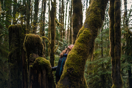 女人在加拿大斯夸米什的森林里抬头看图片