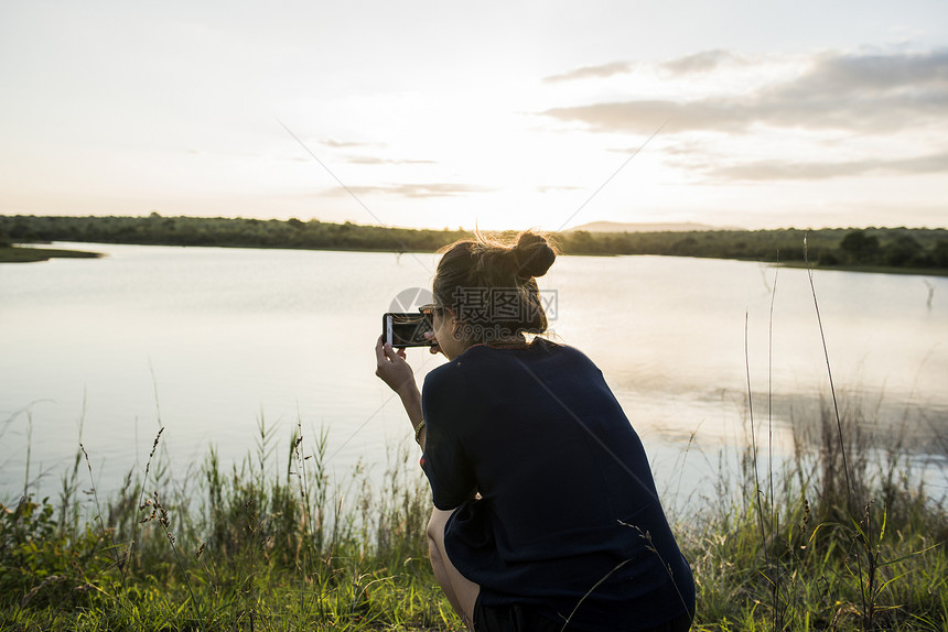 在南非克鲁格公园女青年旅游者拍摄河流照片图片